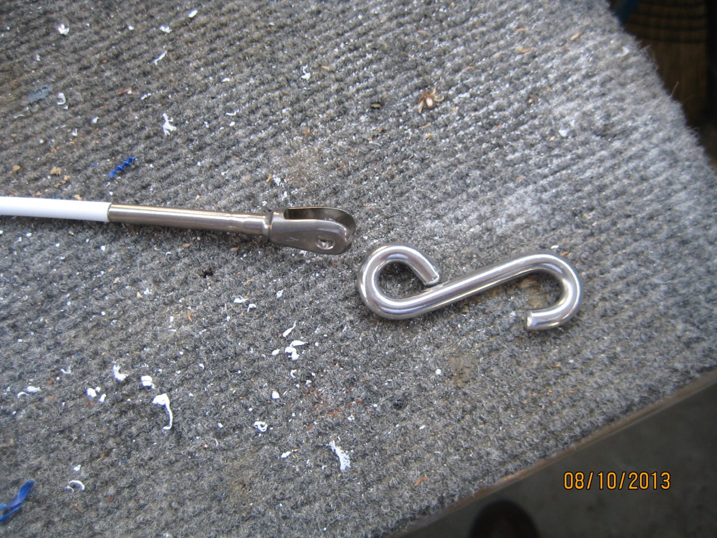 A pair of metal hooks sitting on top of concrete.