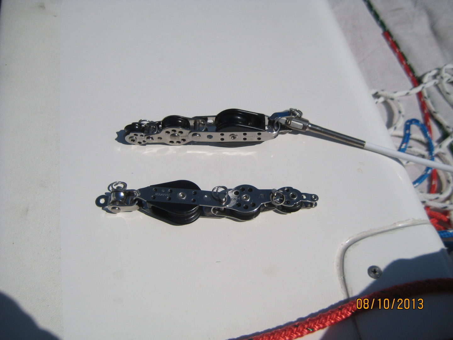 A pair of silver chains hanging on the side of a boat.