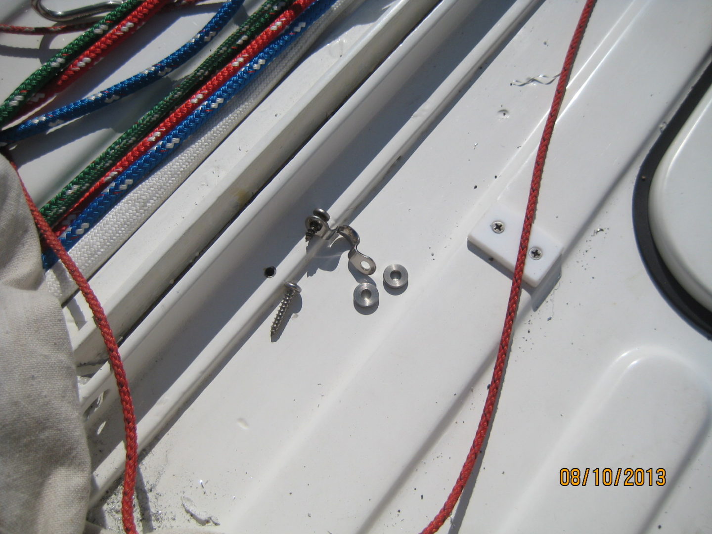 A bunch of wires and some bolts on the side of a boat.