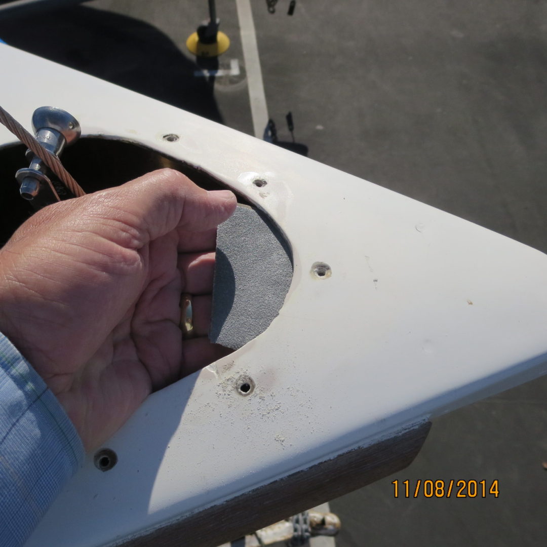 A person holding a piece of metal on top of a boat.