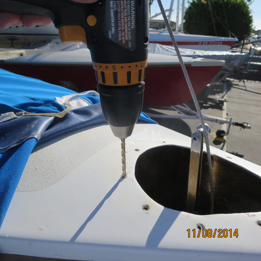 A person using a drill to hole the holes in the boat.