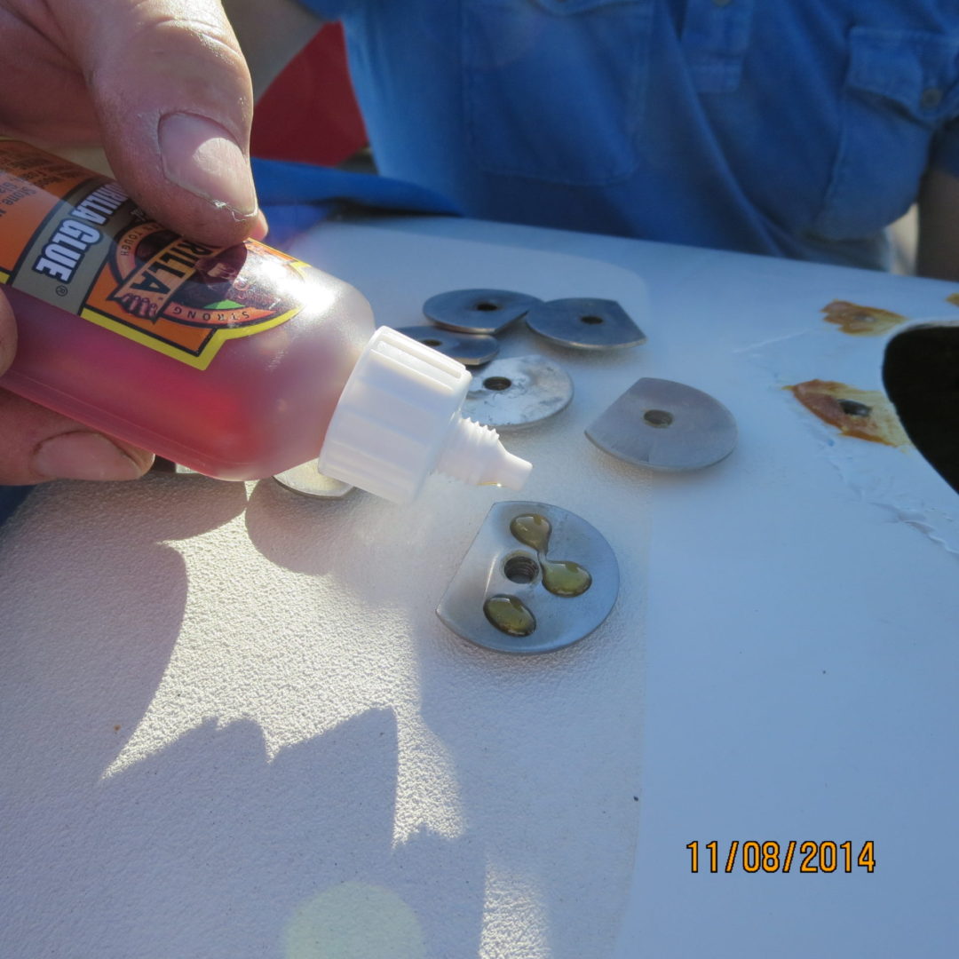 A person is putting glue on the top of a table.