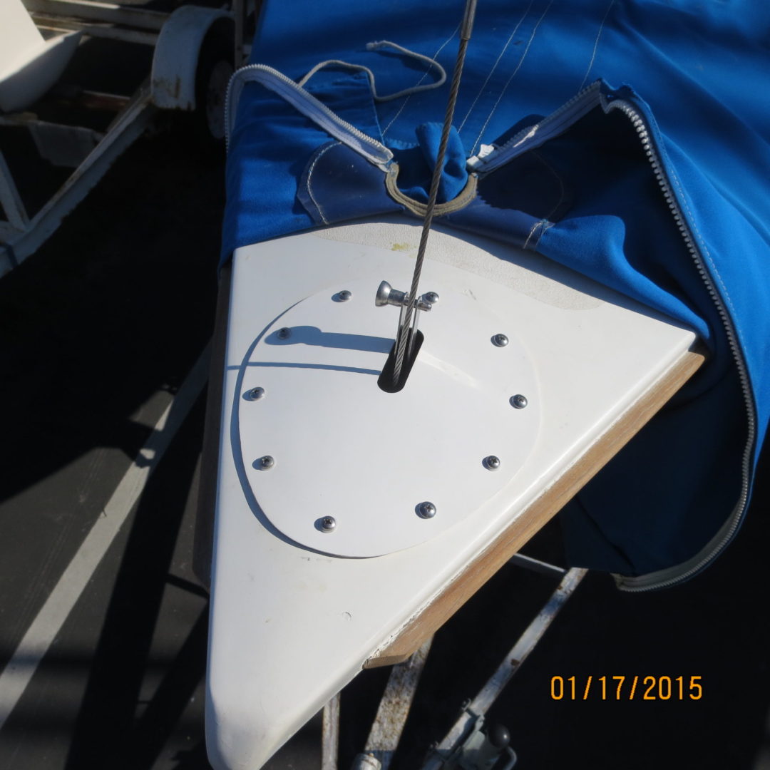 A white sailboat with a blue sail on the side.