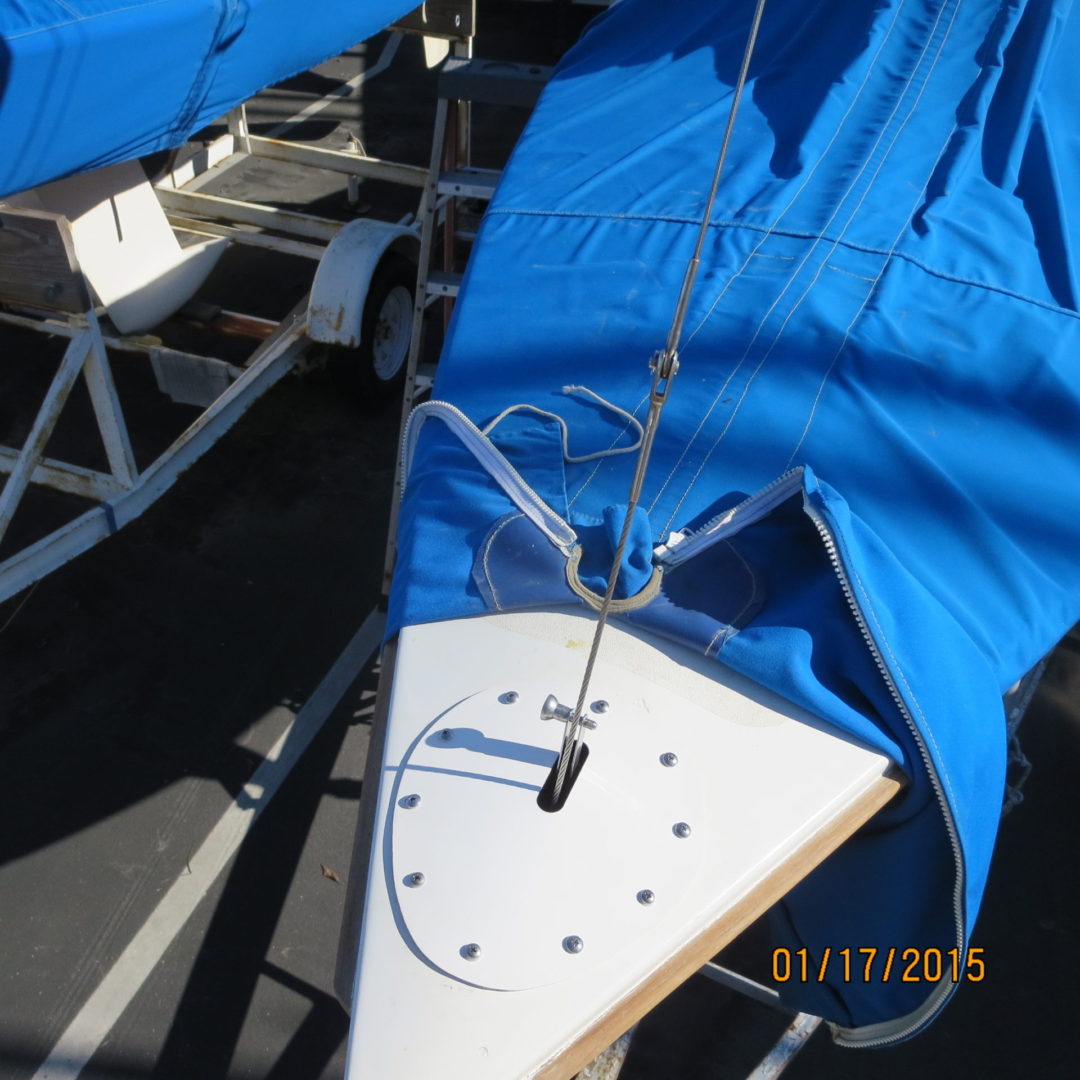 A sailboat with blue sail cover on the side.