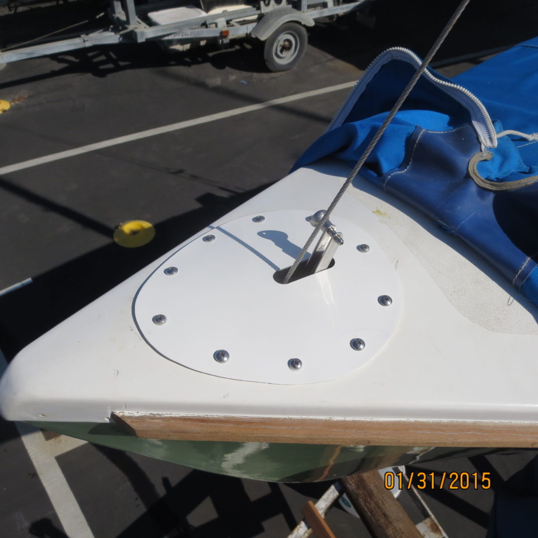 A white boat with a blue cover on the side.