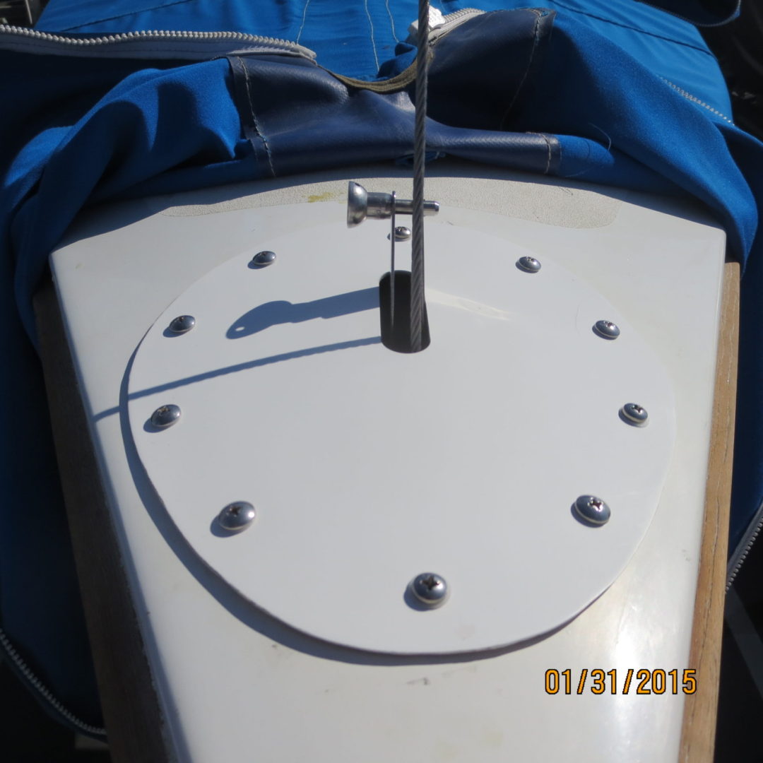 A white boat with a blue cover on the side.