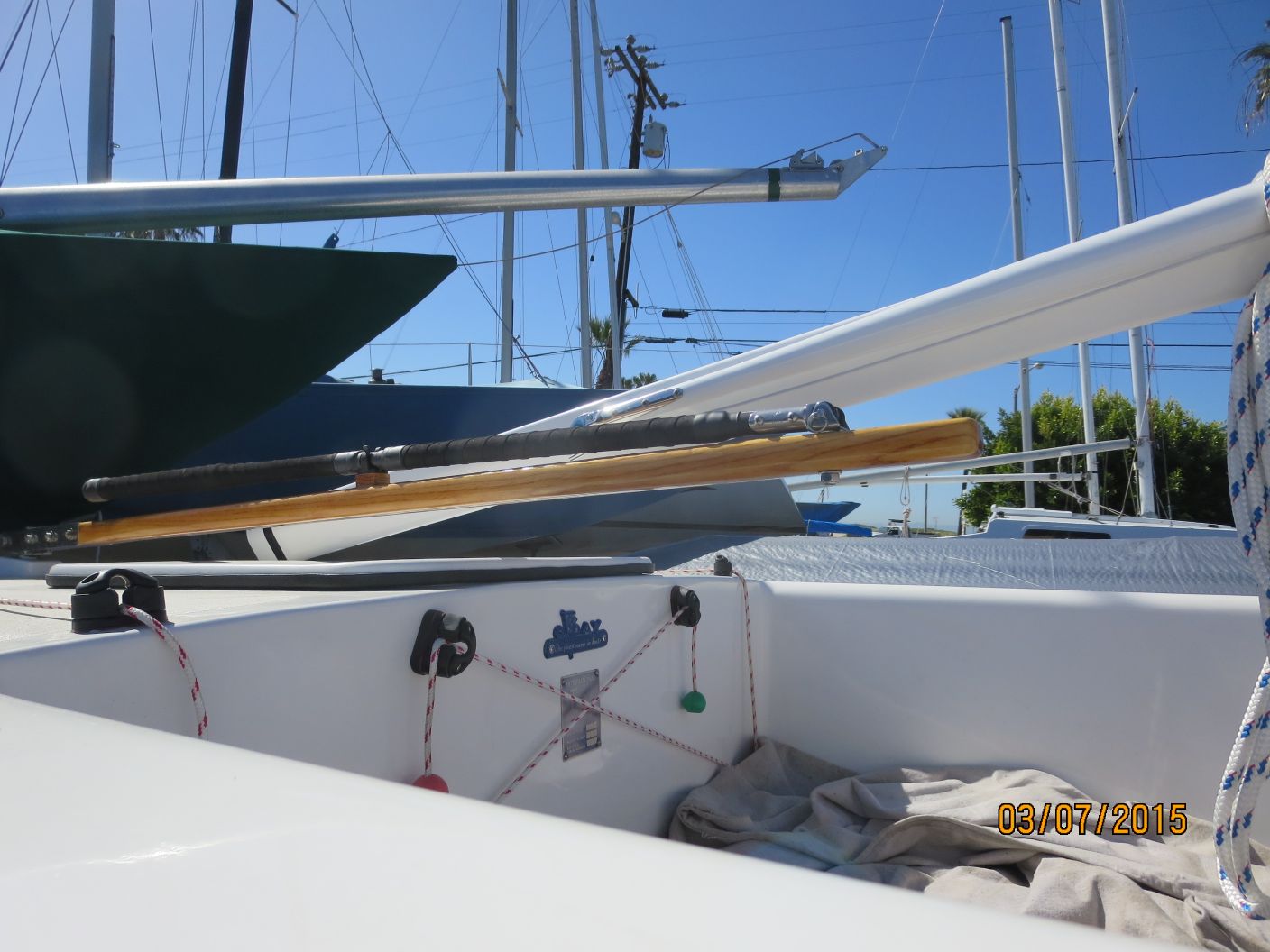 A boat is docked in the water and has two ropes hanging from it.