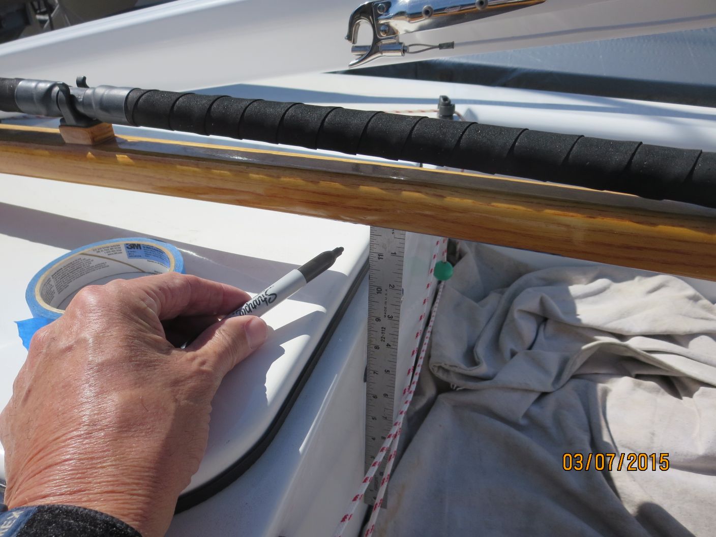 A person writing on paper next to a boat.