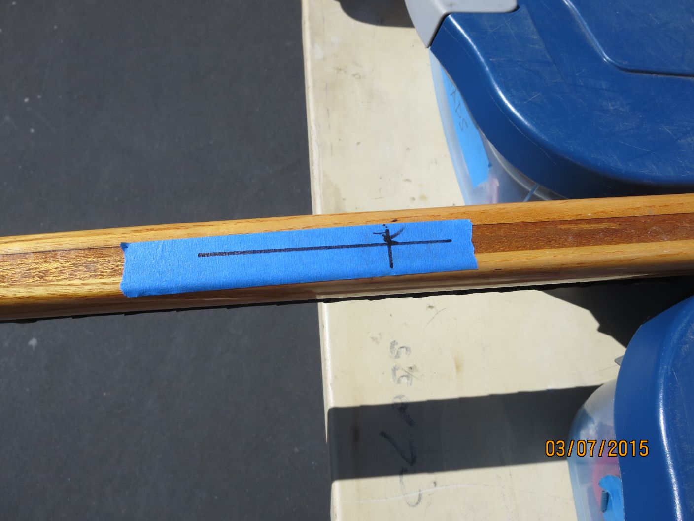 A wooden stick with blue tape on it.