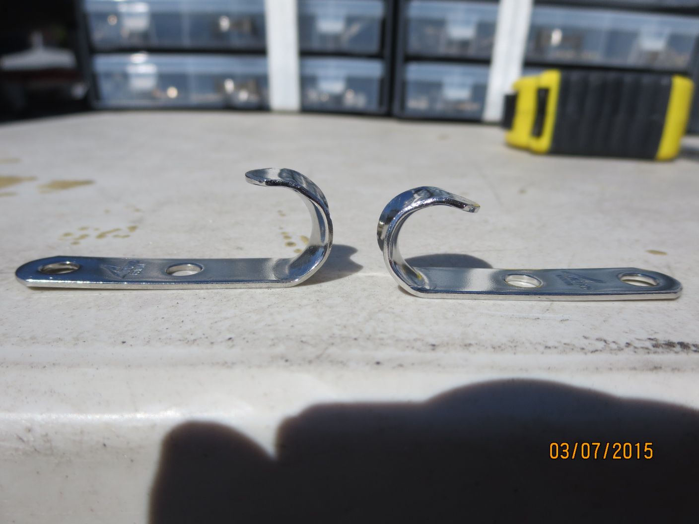 A pair of metal hooks sitting on top of a cement floor.