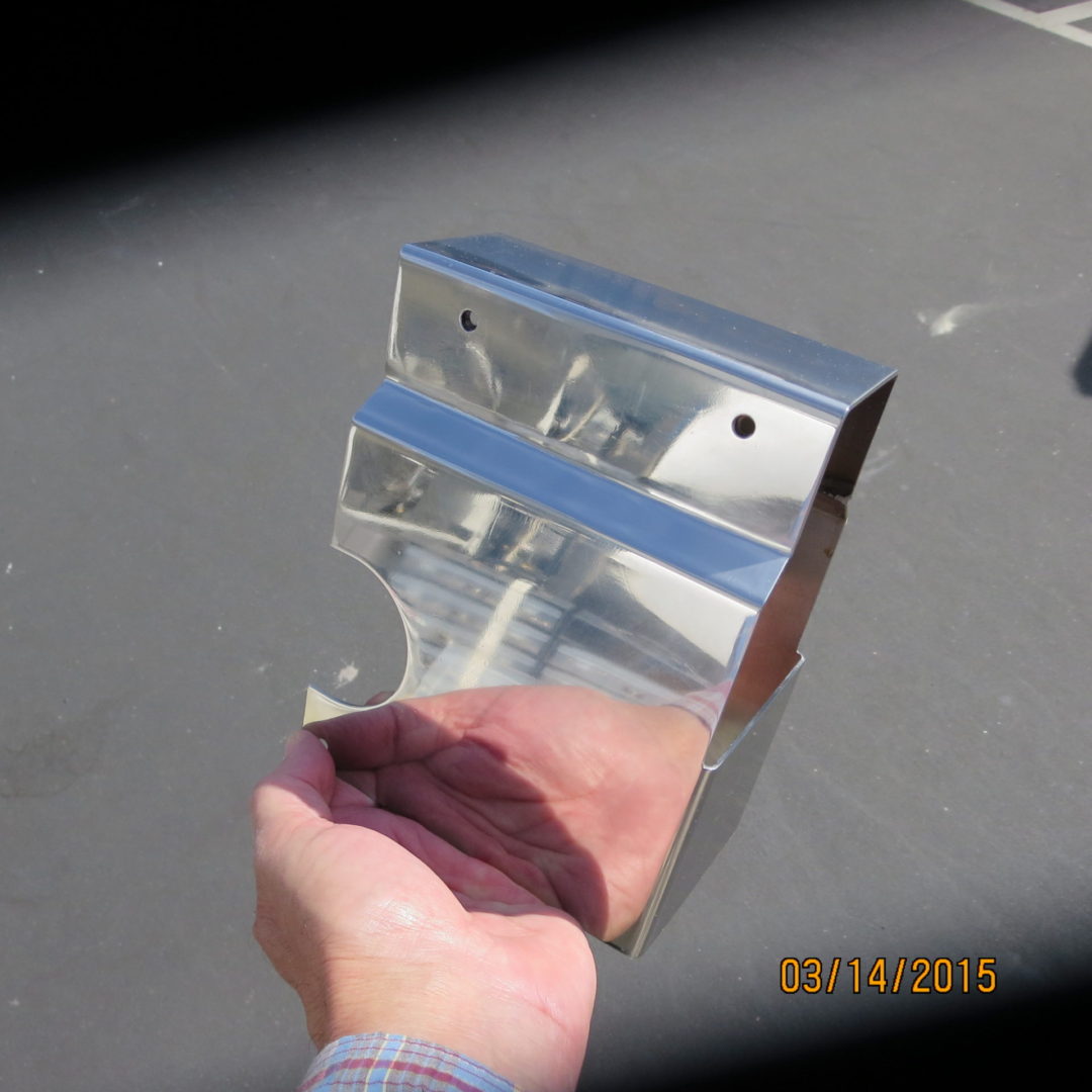 A hand holding up a metal object on top of a table.