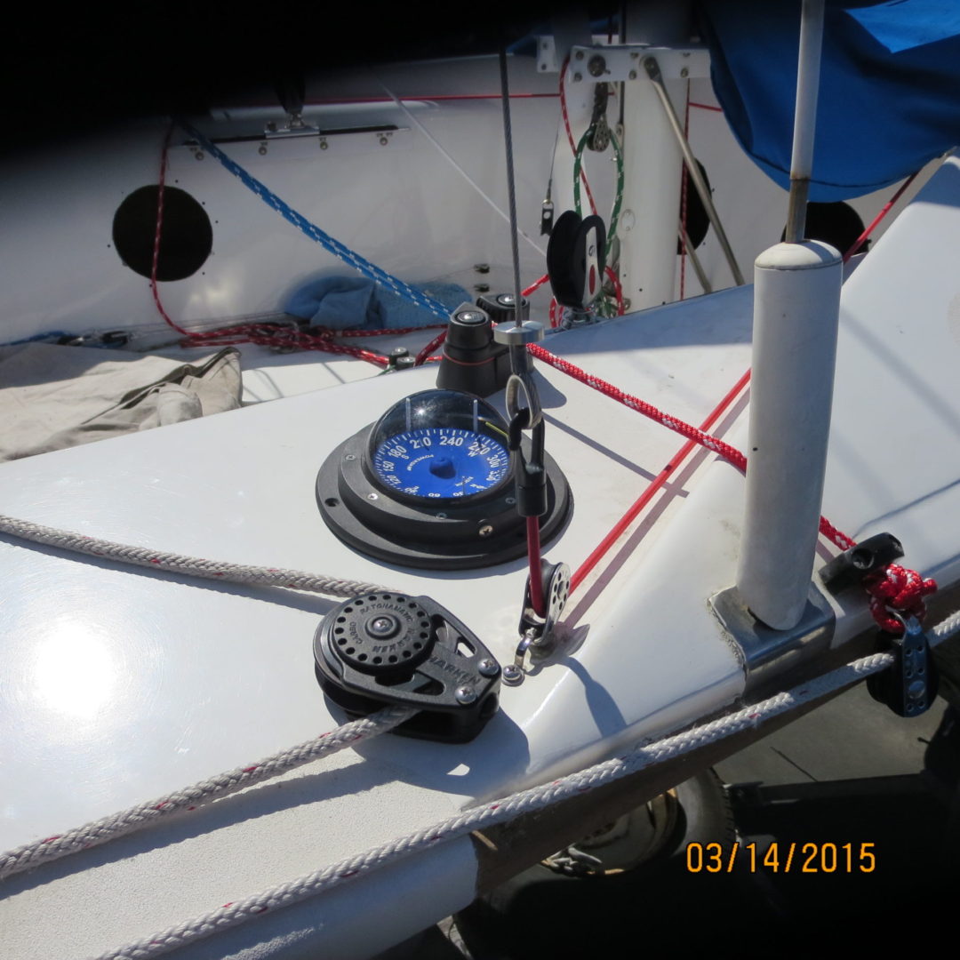 A sailboat with two ropes and a compass on the side.