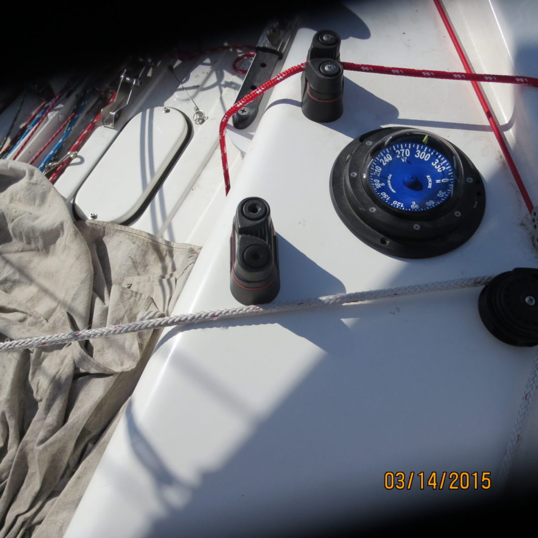 A sailboat with two winches and a compass on the side.