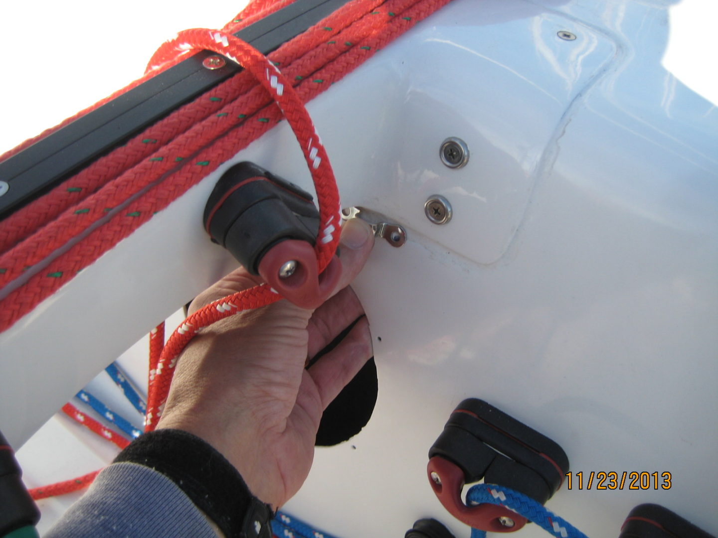 A person holding onto the red rope on a boat.