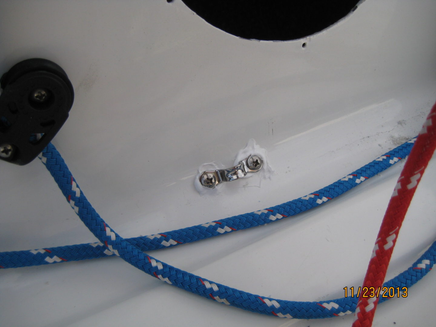 A blue and white rope is tied to the side of a boat.