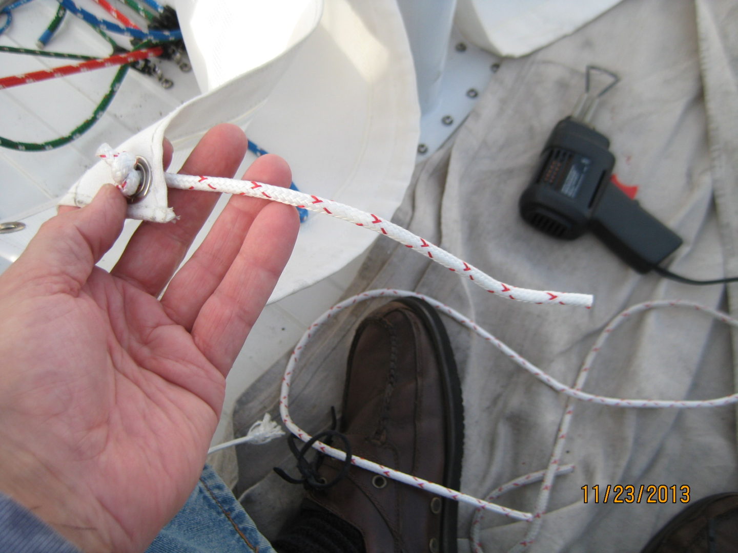 A person holding up a string with white and red tape.