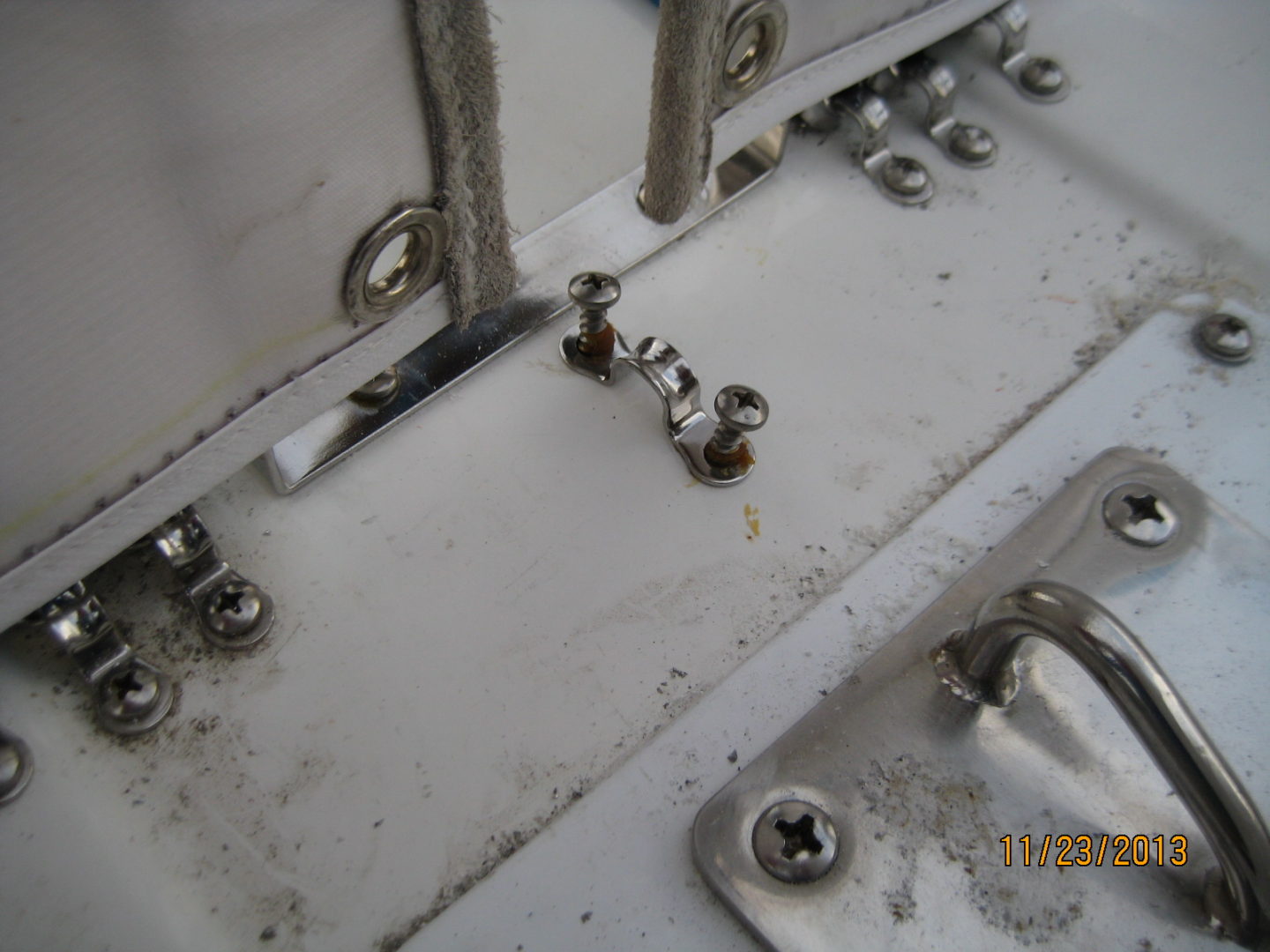 A close up of the side of a boat with some bolts and nuts.