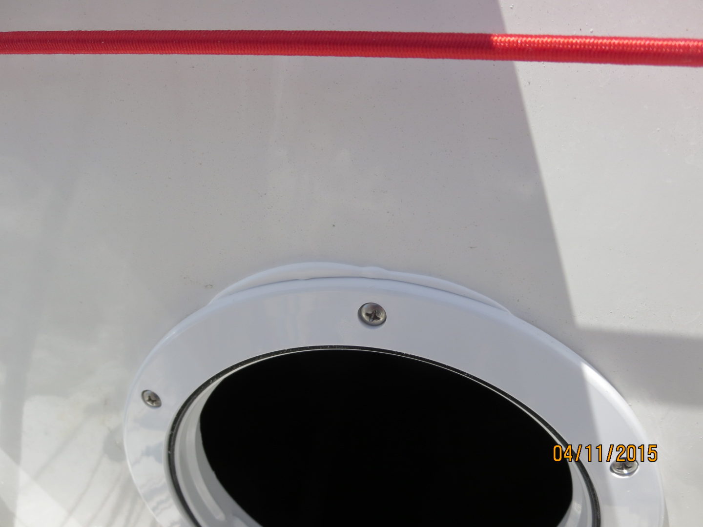 A close up of the side of a boat with a red line on it.