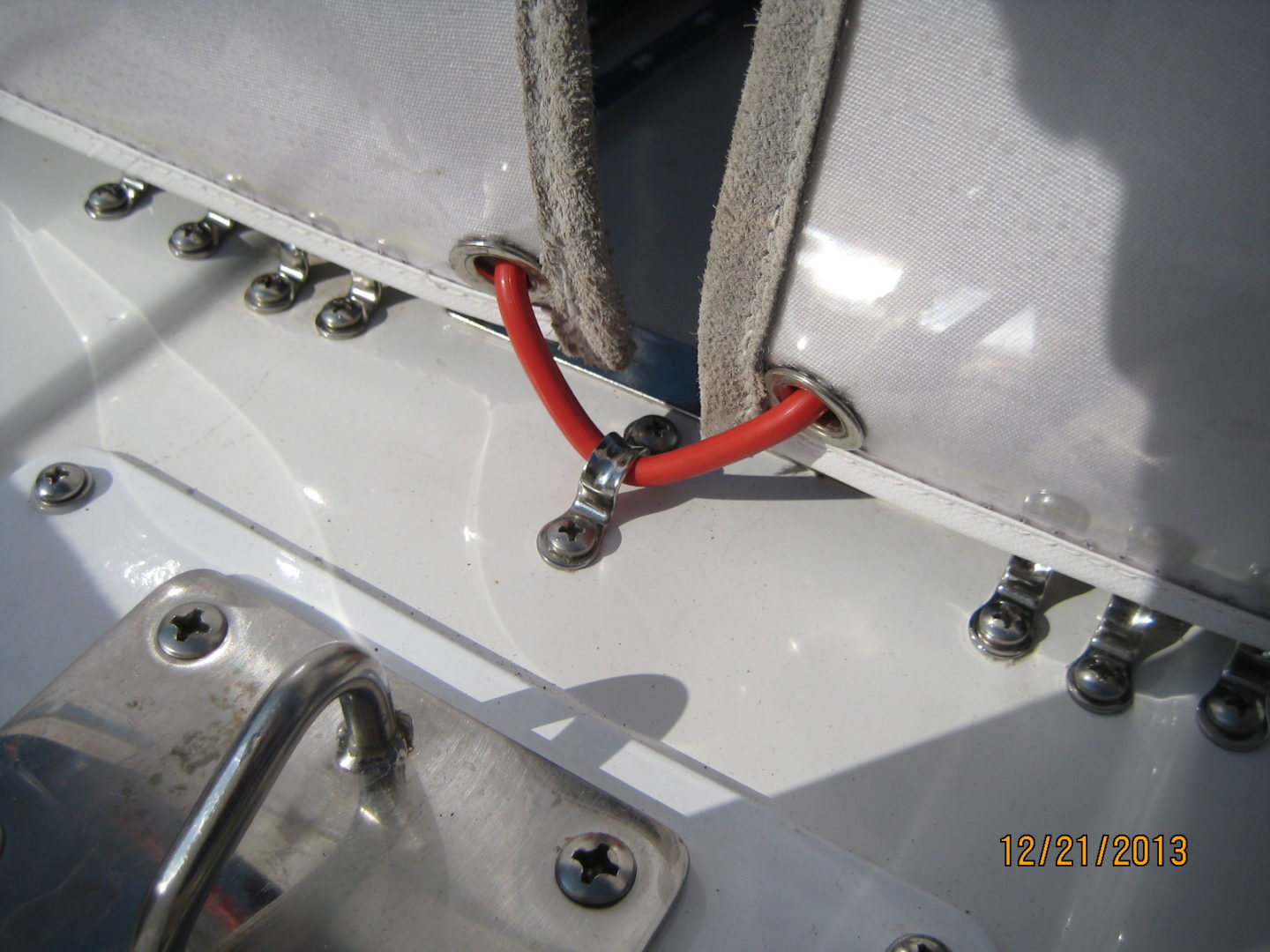 A red wire is attached to the side of a boat.