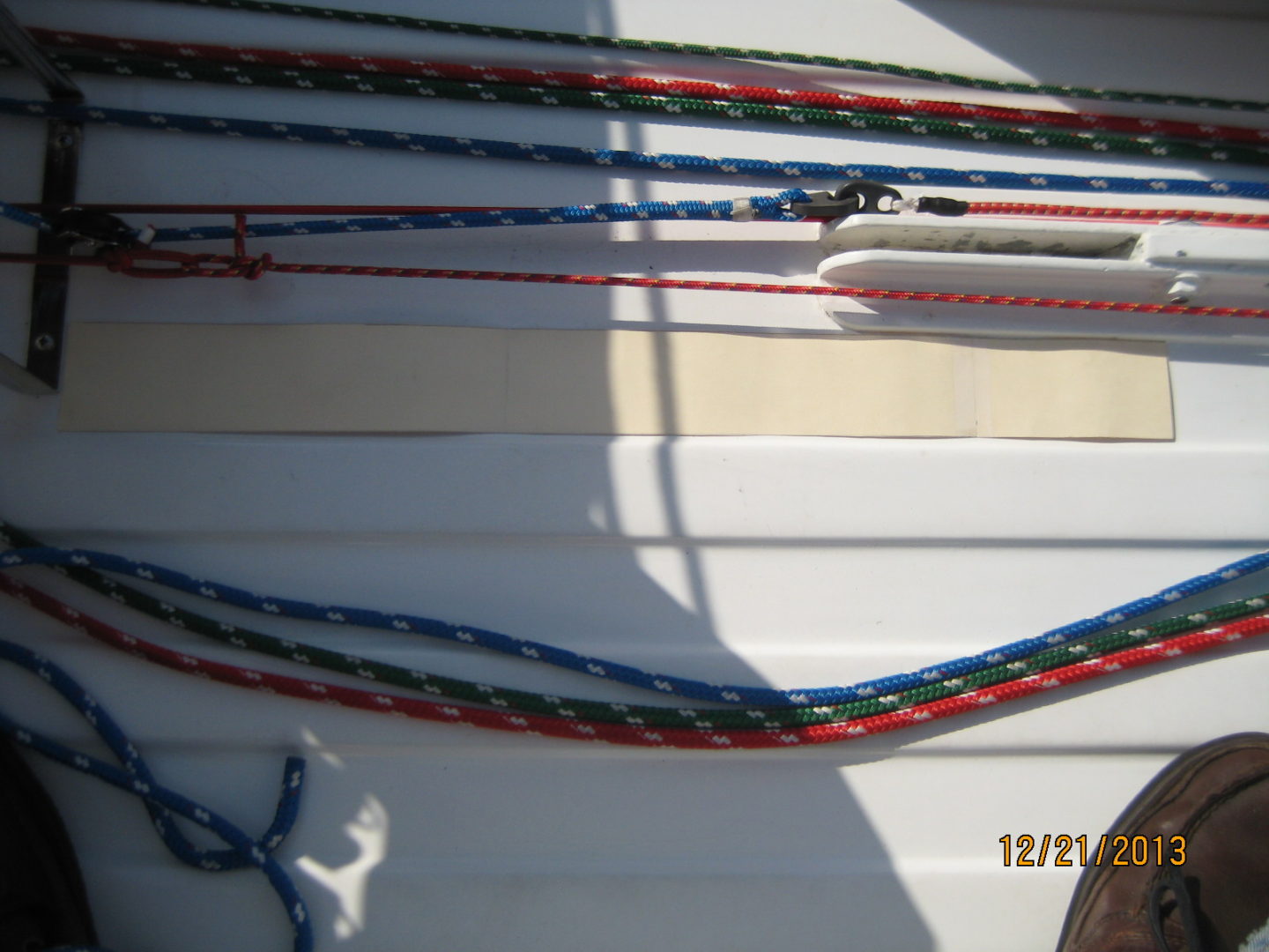 A bunch of ropes hanging on the side of a boat.