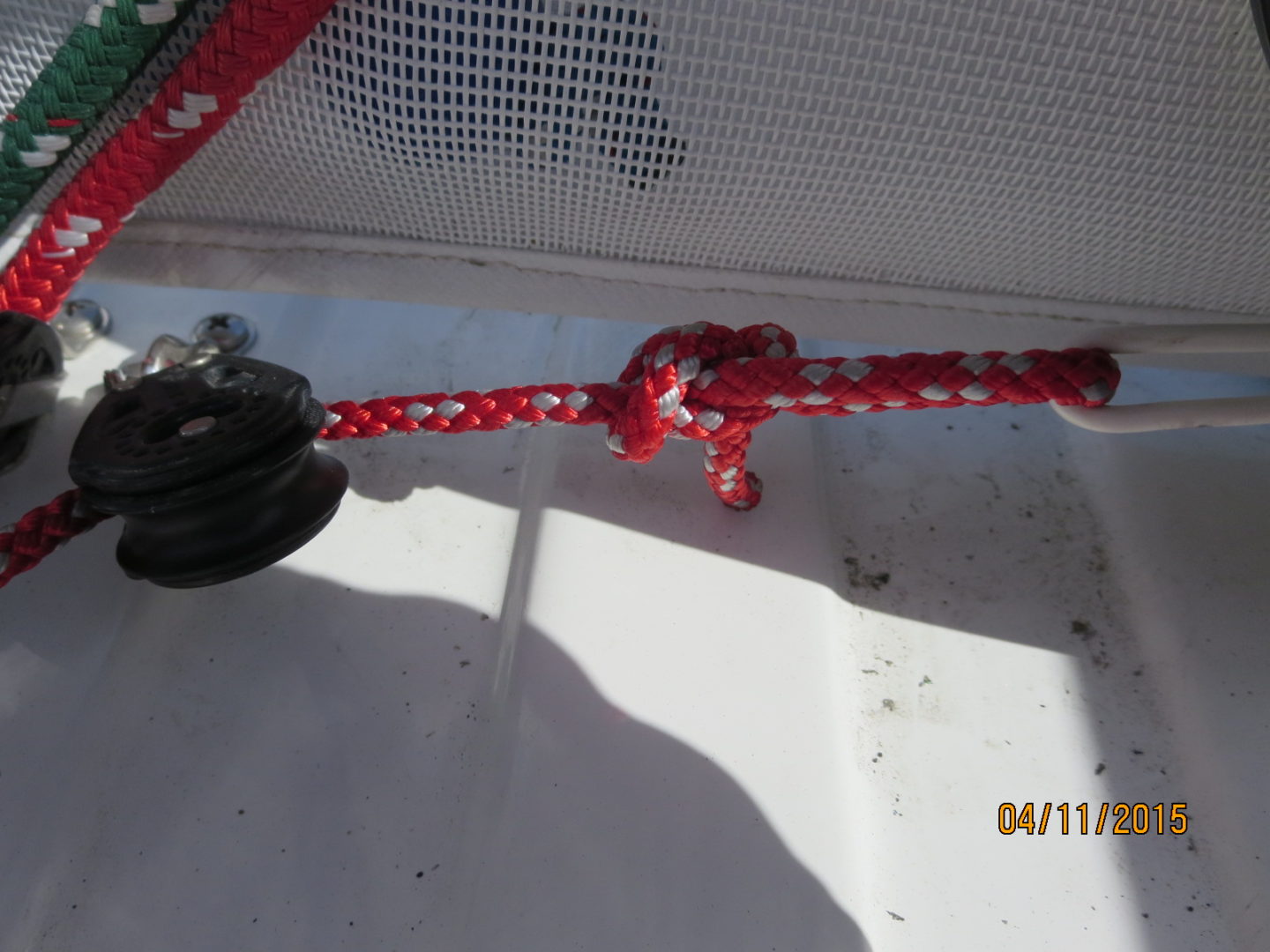 A red and white rope hanging from the side of a boat.