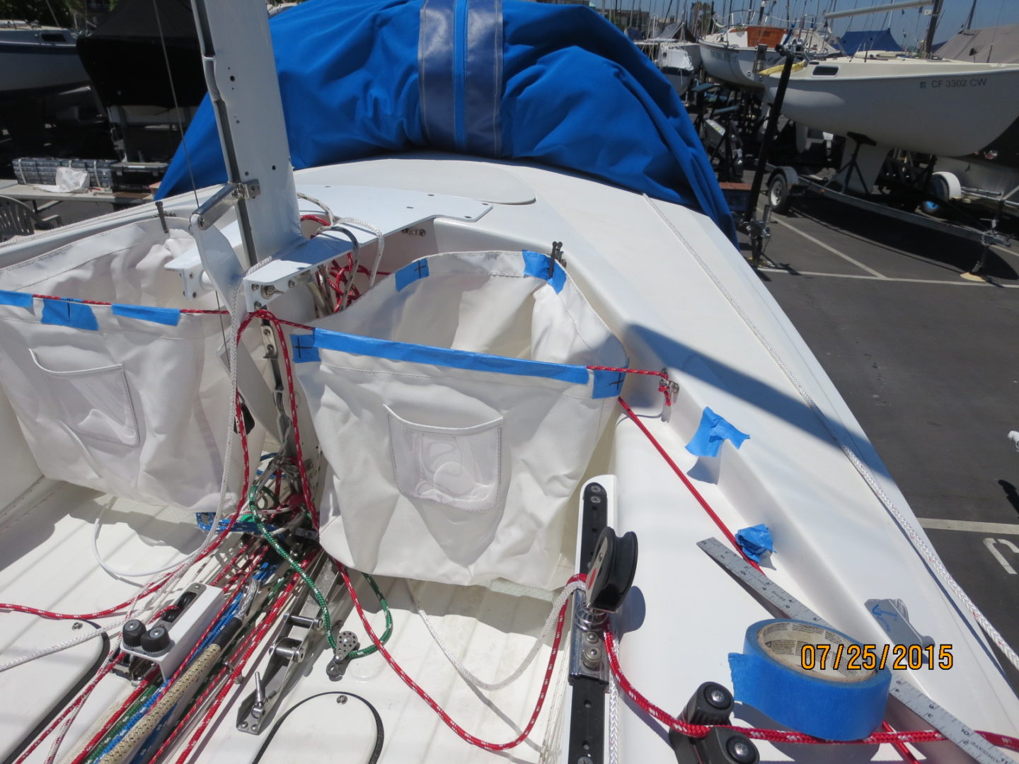 A boat with blue tarps and ropes on the deck.