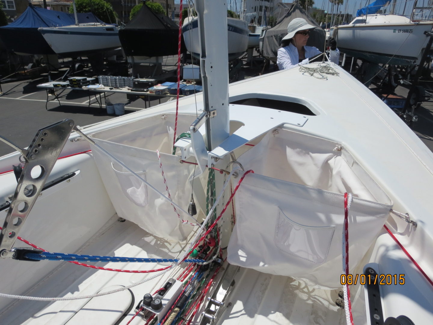 A boat with a sail on it is tied to the side of a dock.