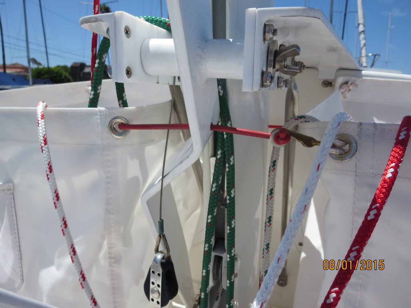 A white sailboat with many ropes hanging from it's side.