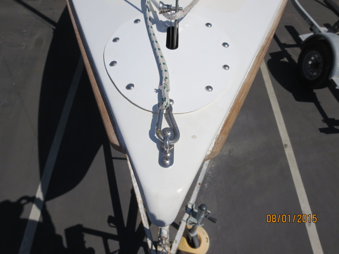 A white sailboat with a chain and hook attached to it.