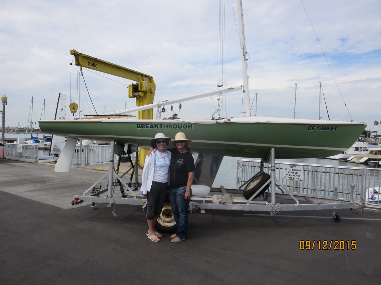 Two men standing next to a boat on the water.