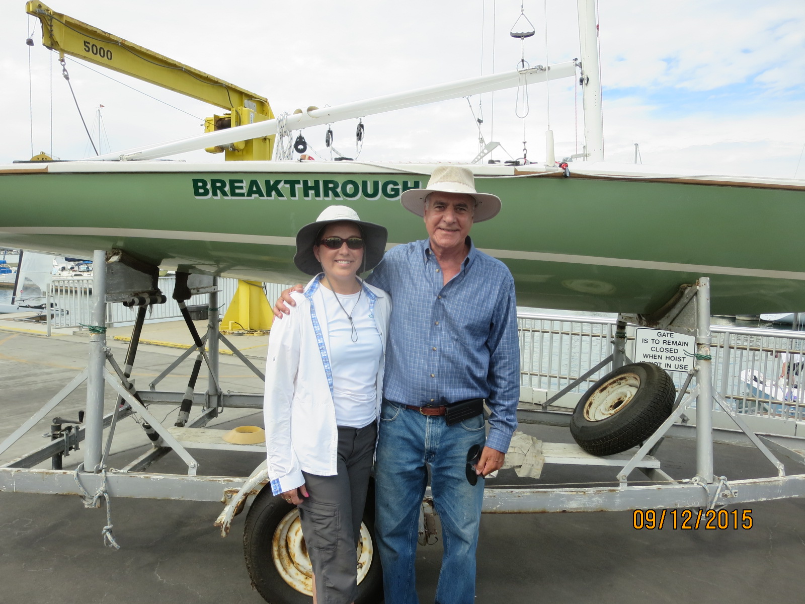 A man and woman standing in front of a boat.