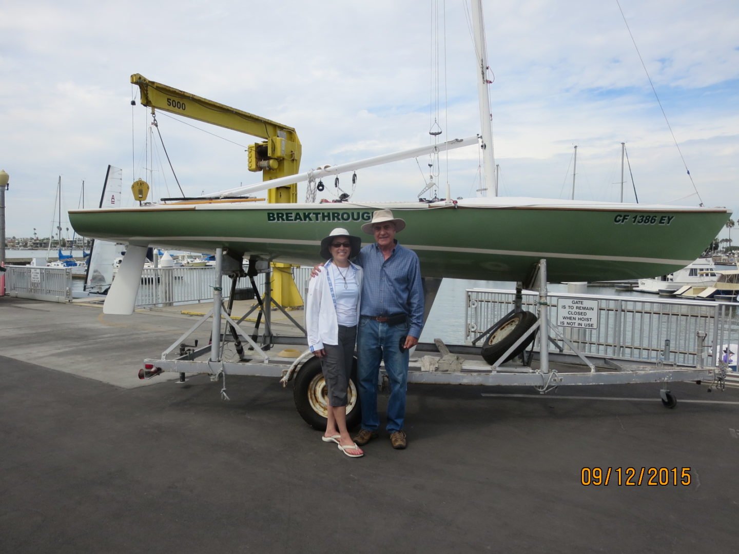 A man and woman standing in front of a boat.