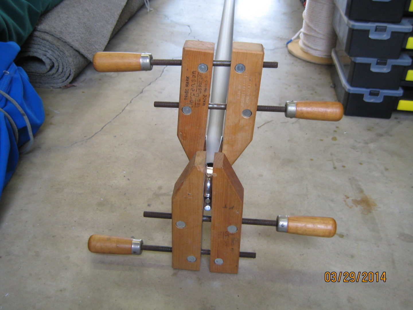 A wooden clamp with wood handles attached to it.