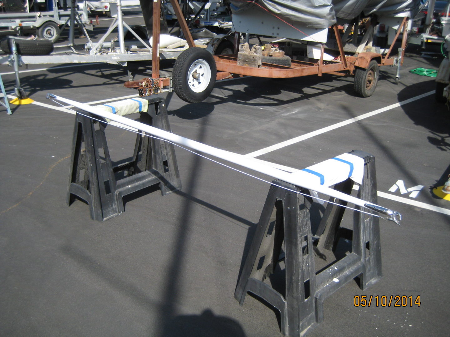 A boat is parked on the ground in an empty parking lot.