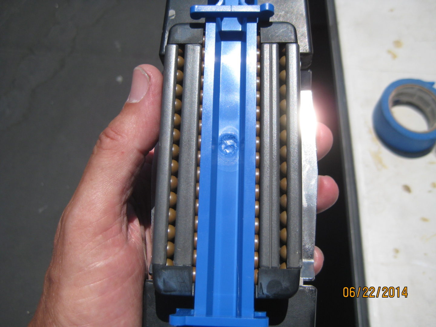 A hand holding an electric drill with blue plastic.