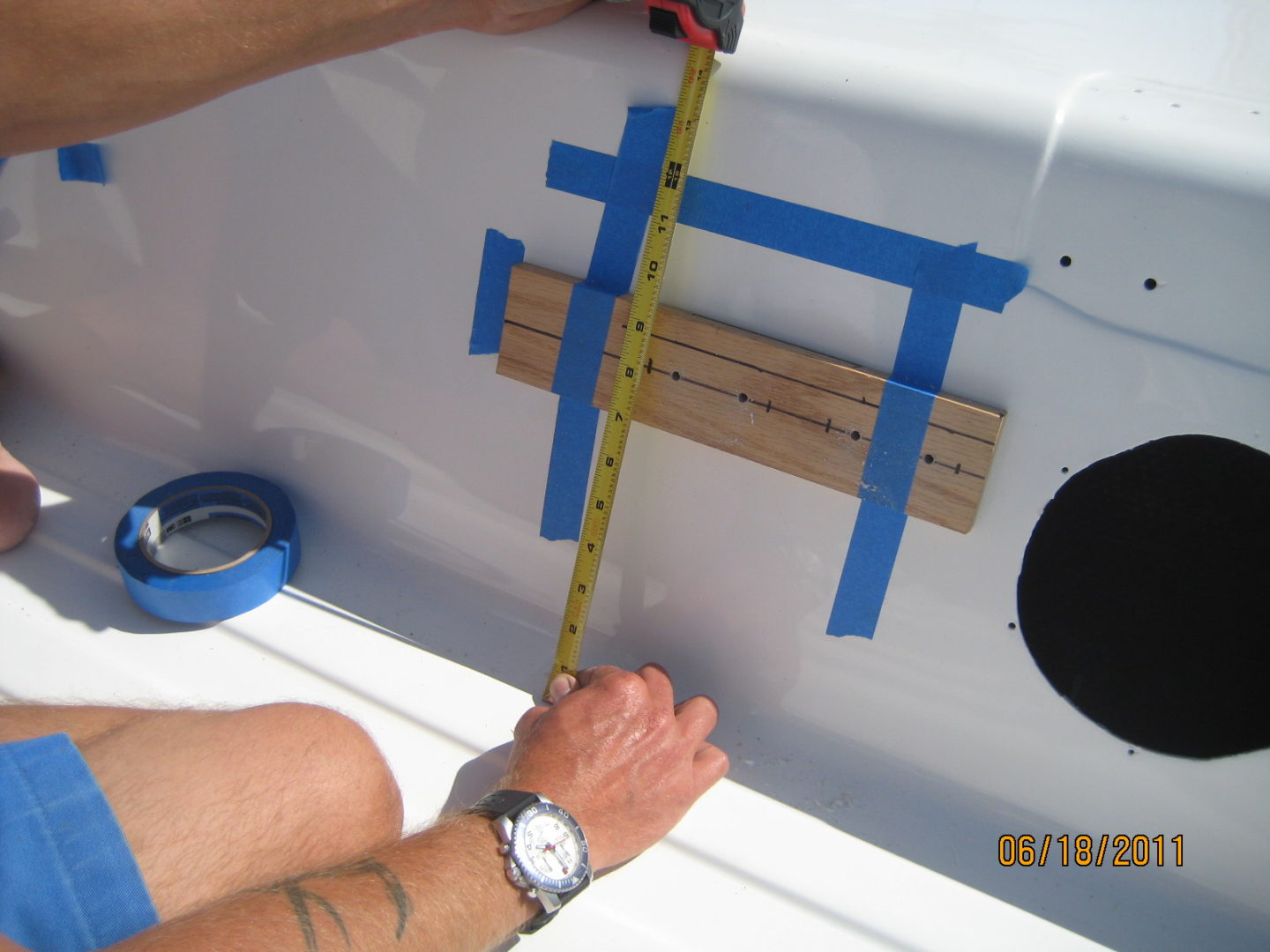 A person measuring the length of a boat