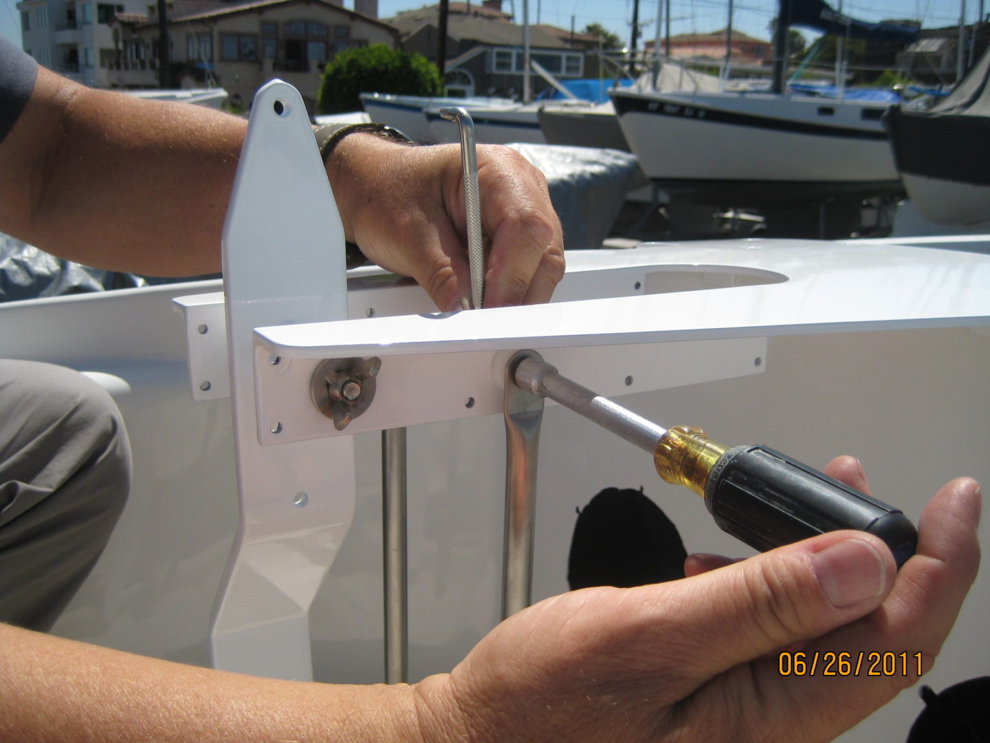 A person using a pair of scissors to cut the side of a boat.