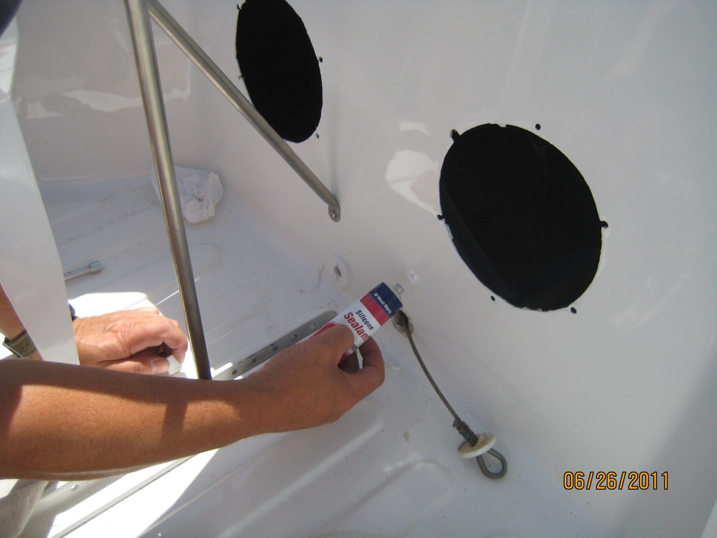 A person is painting holes in the wall of a bathroom.