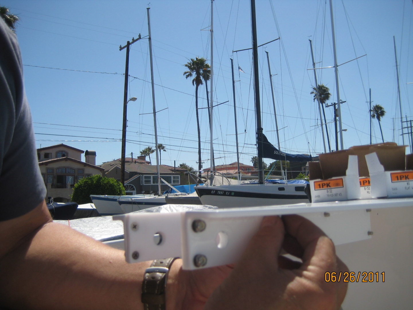 A person holding up a camera to take a picture of some boats.