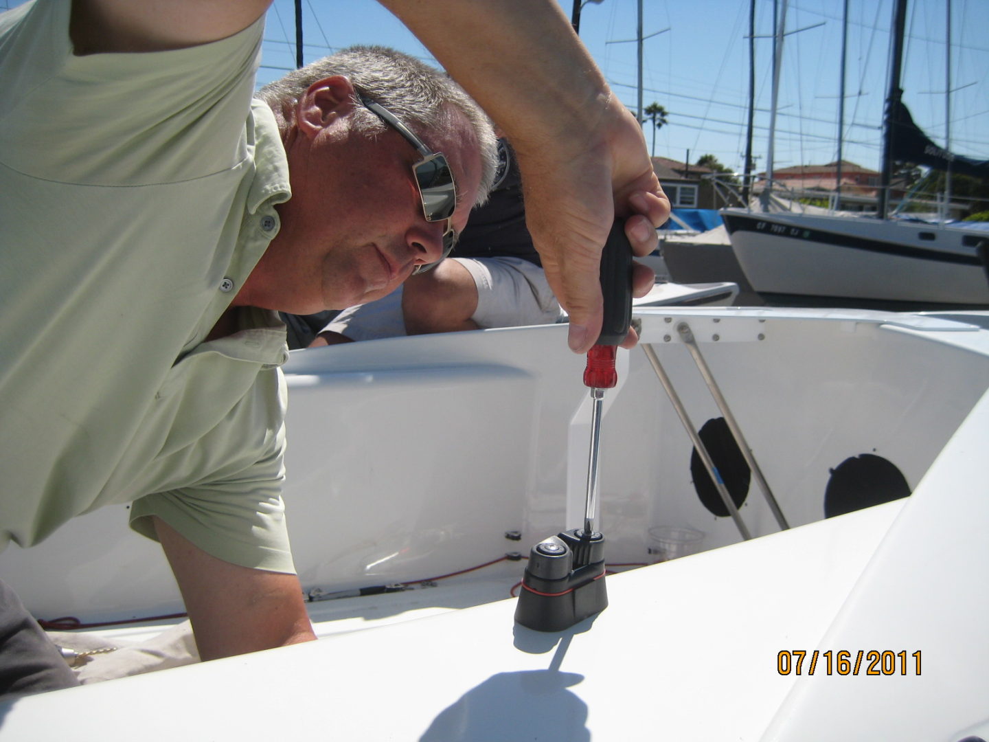 A man is working on the side of a boat.