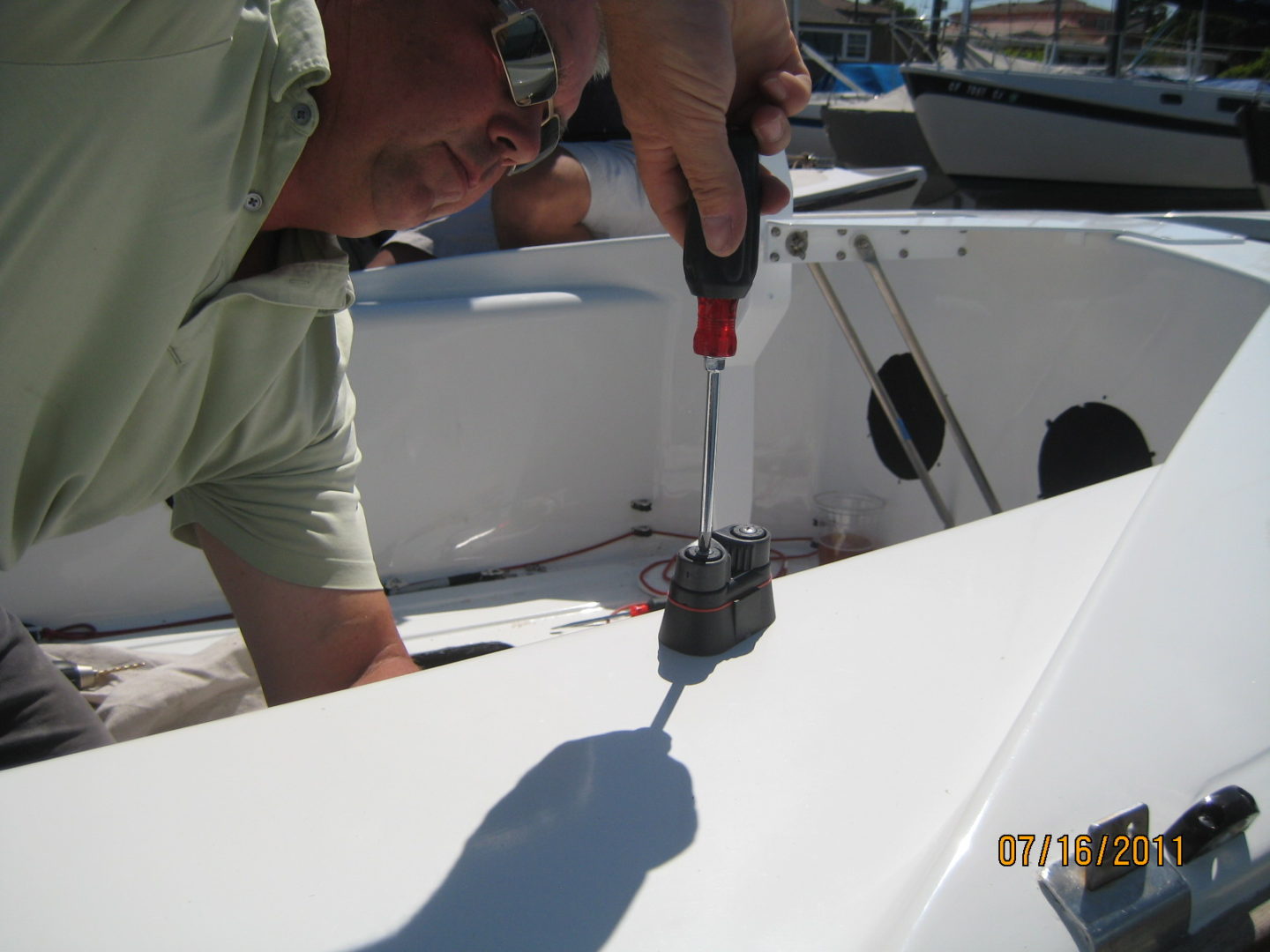 A man is working on the side of a boat.