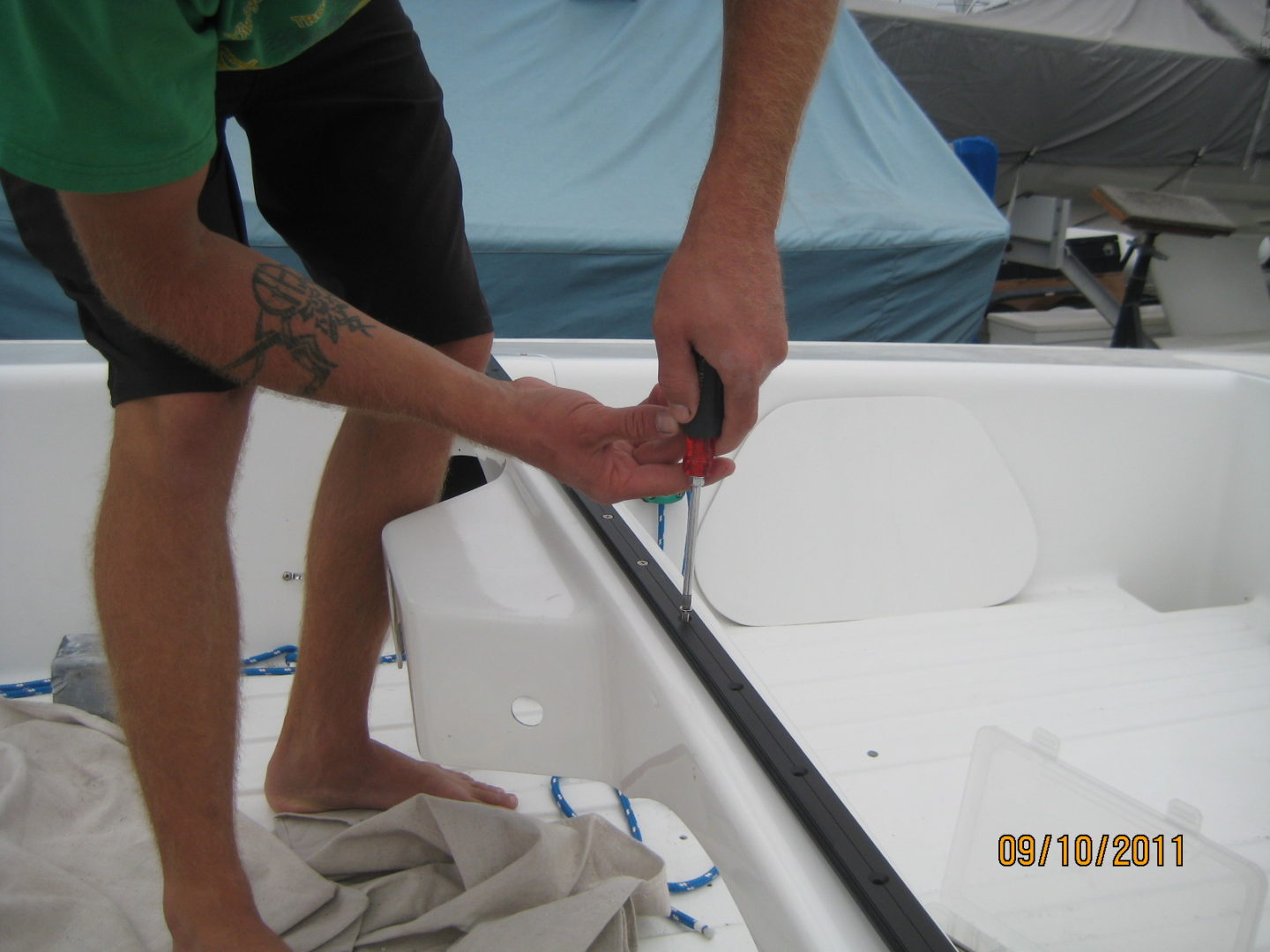 A man is cutting the bottom of a boat.