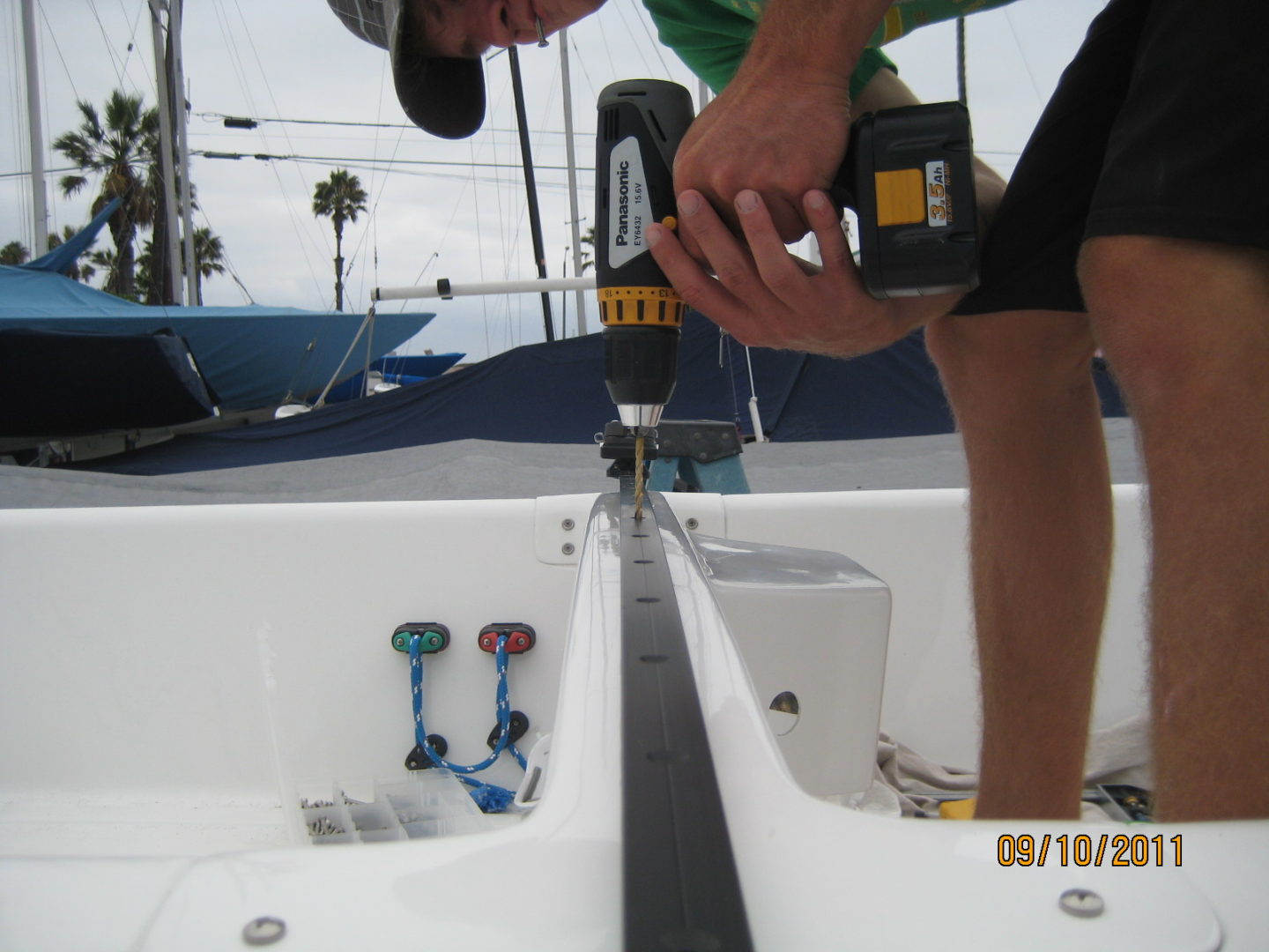 A man using a drill to install the front of a boat.