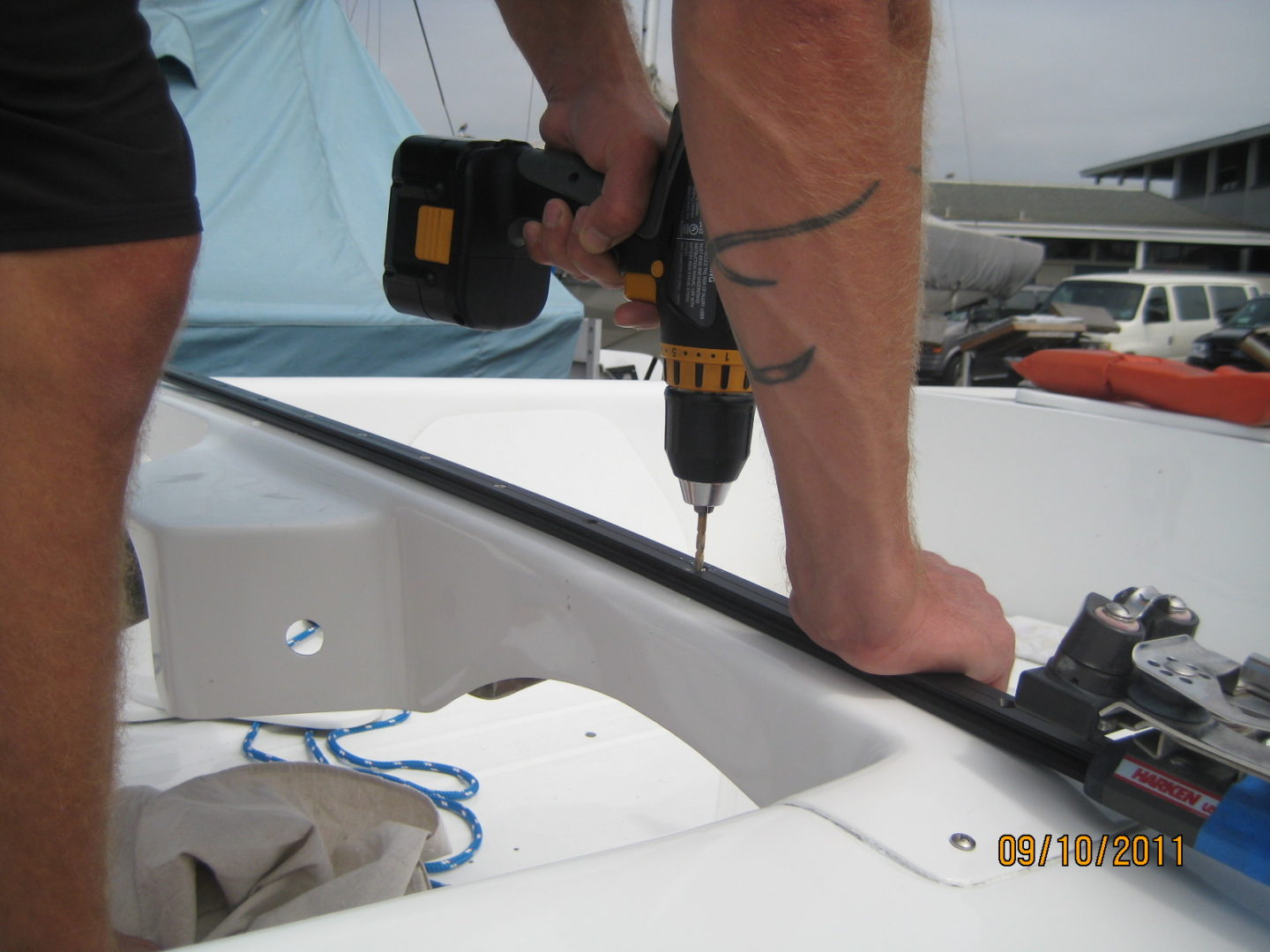 A man using a drill to install the roof of a boat.