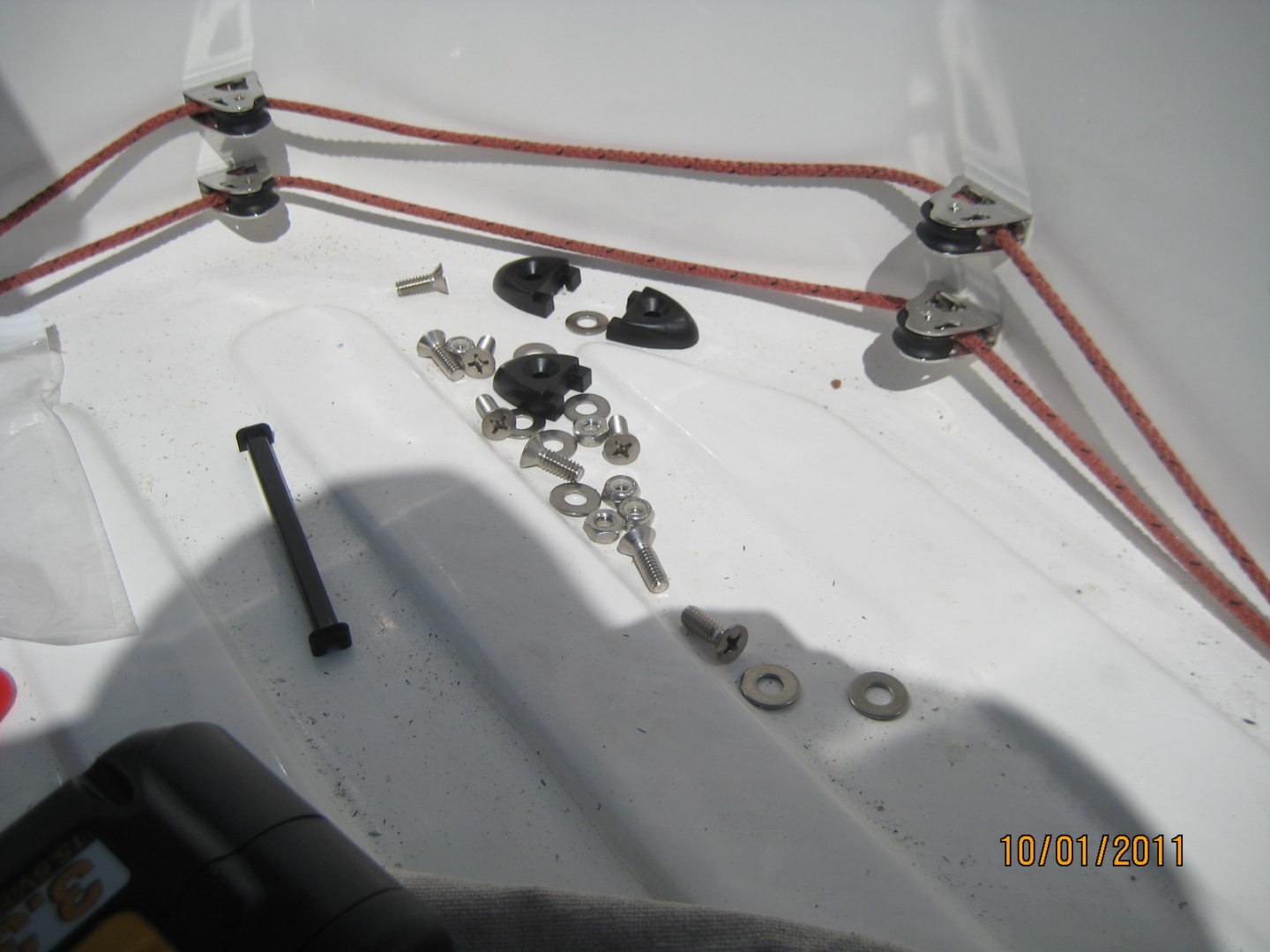 A close up of some wires and nuts on the side of a boat.