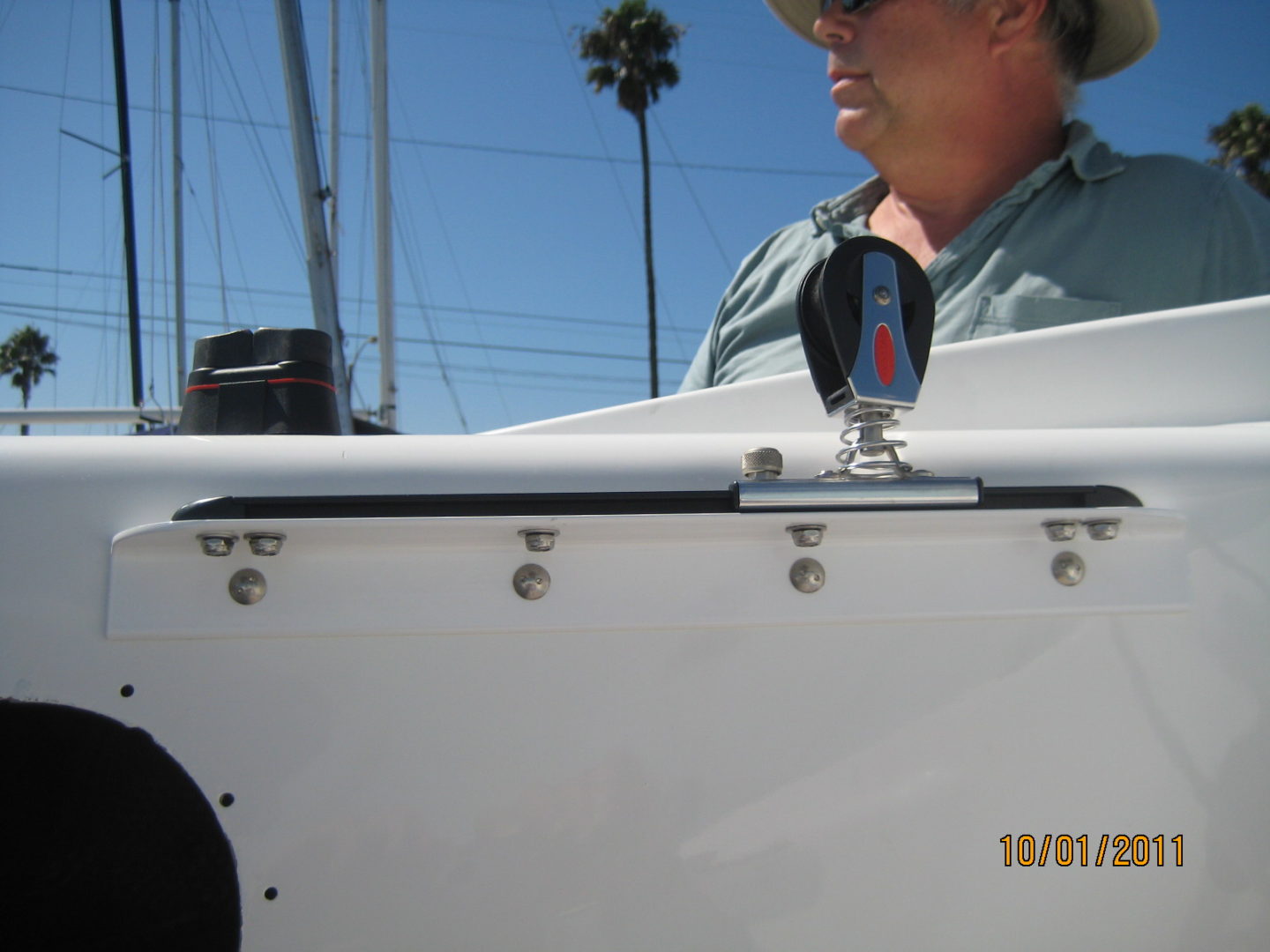 A man in a hat is standing next to a boat.