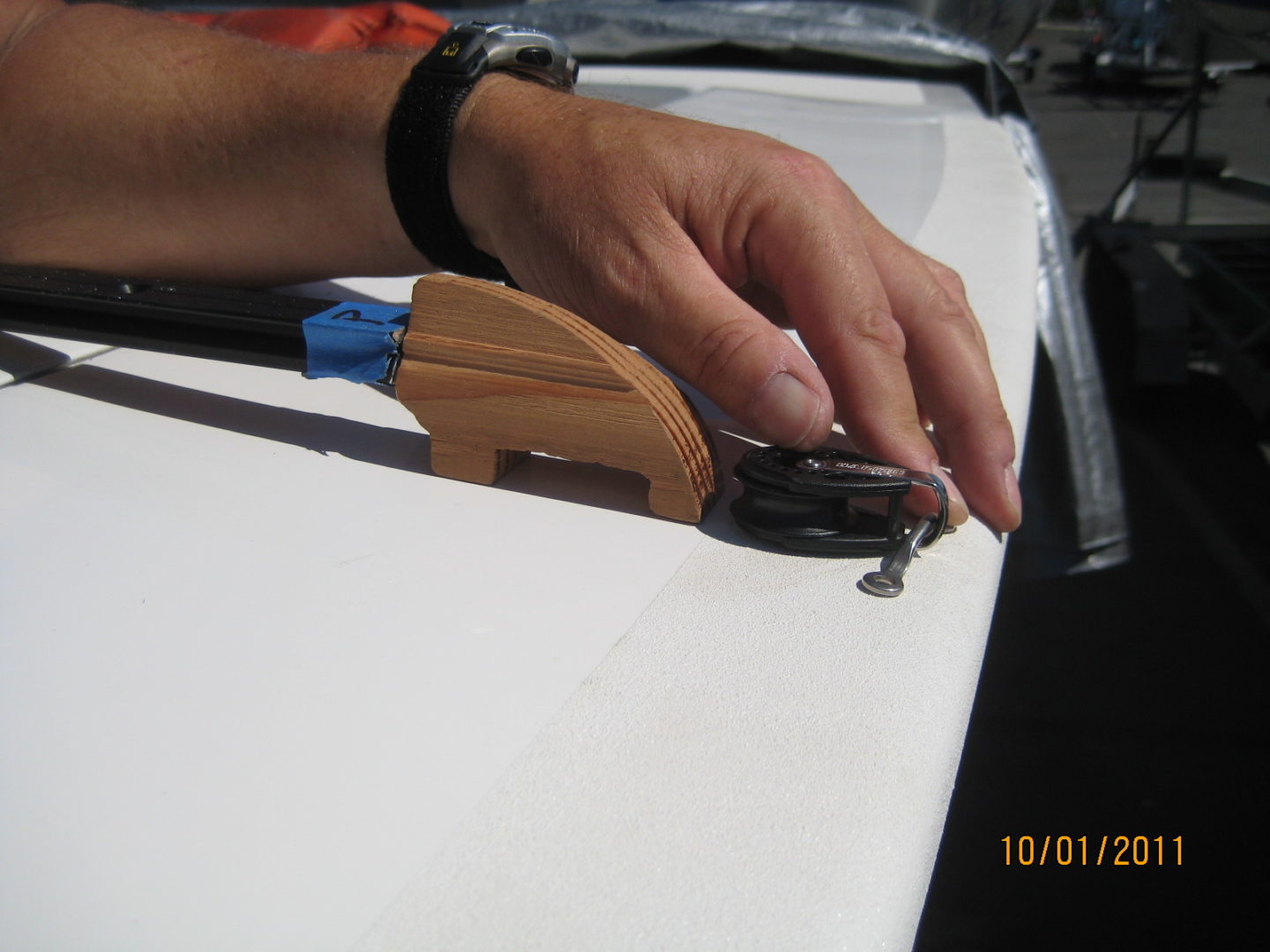 A person holding pliers and nails on top of a table.