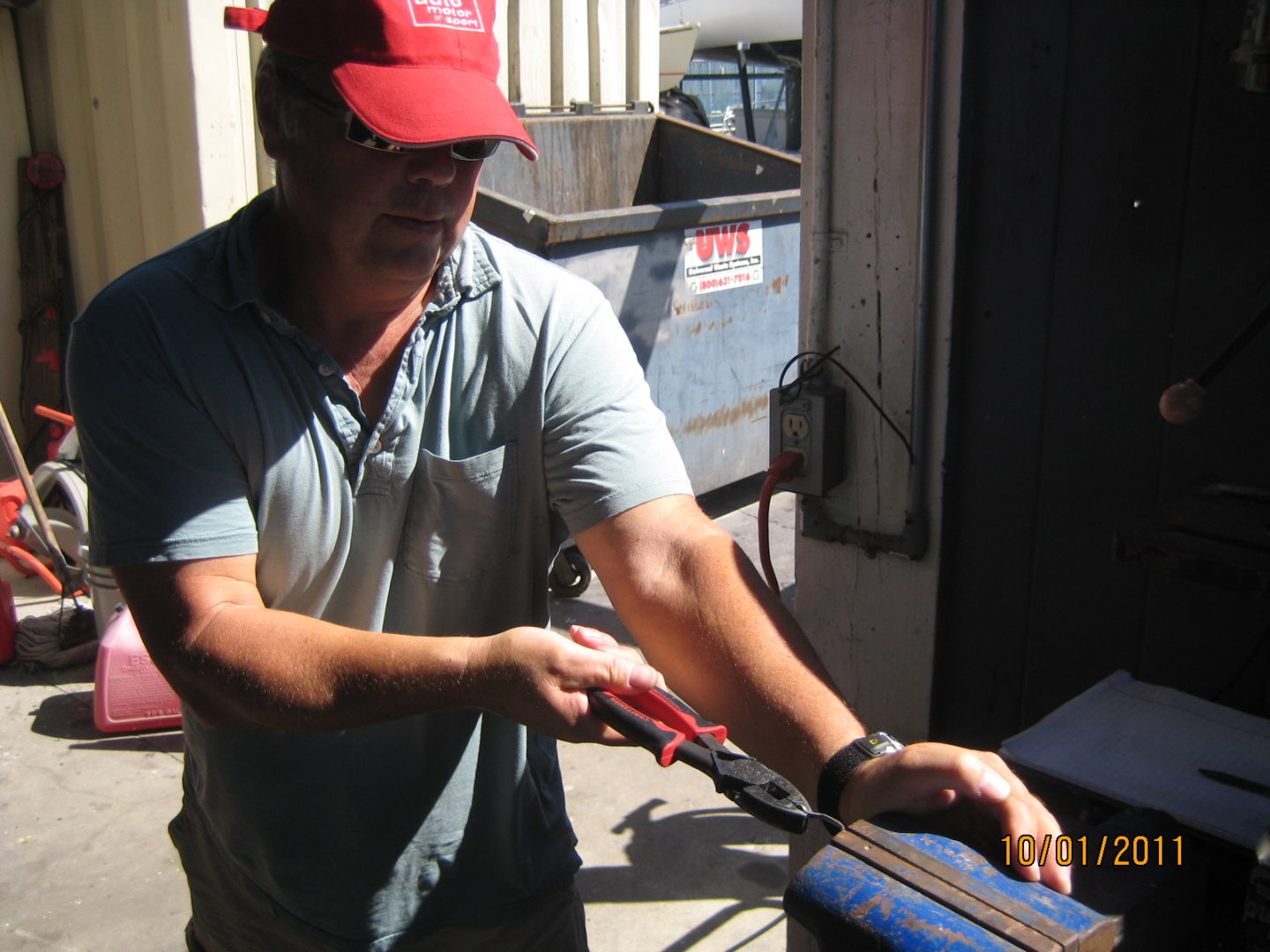 A man holding a pair of red scissors.