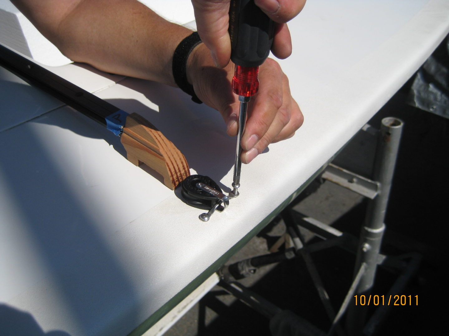 A person using a pair of scissors to cut the wire.