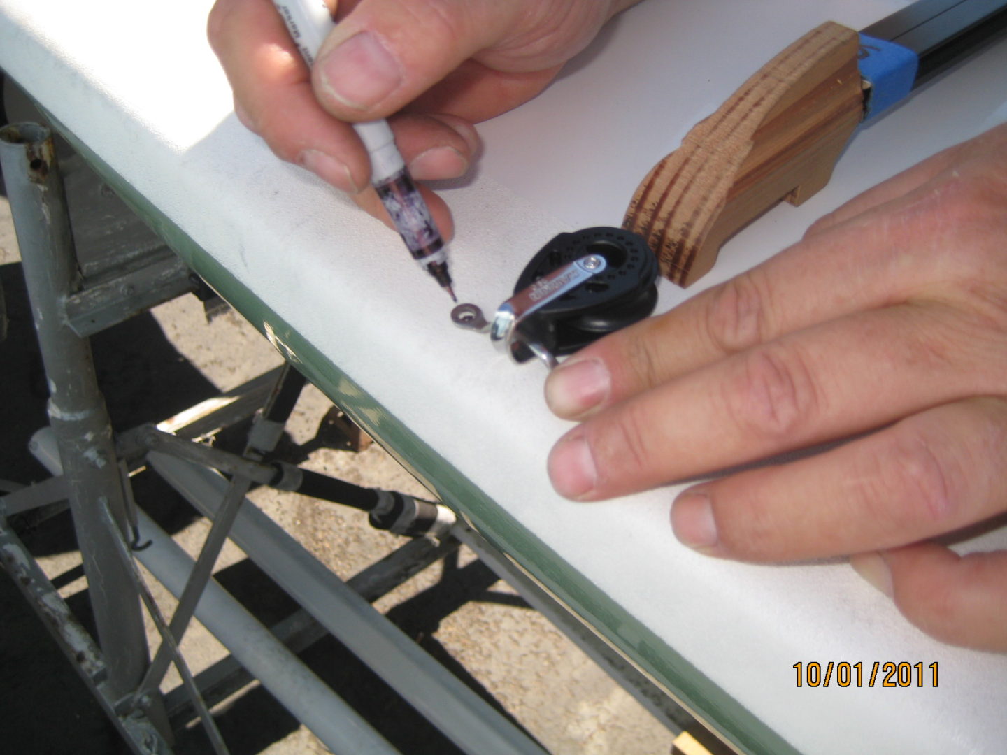 A person is writing on the side of a table.